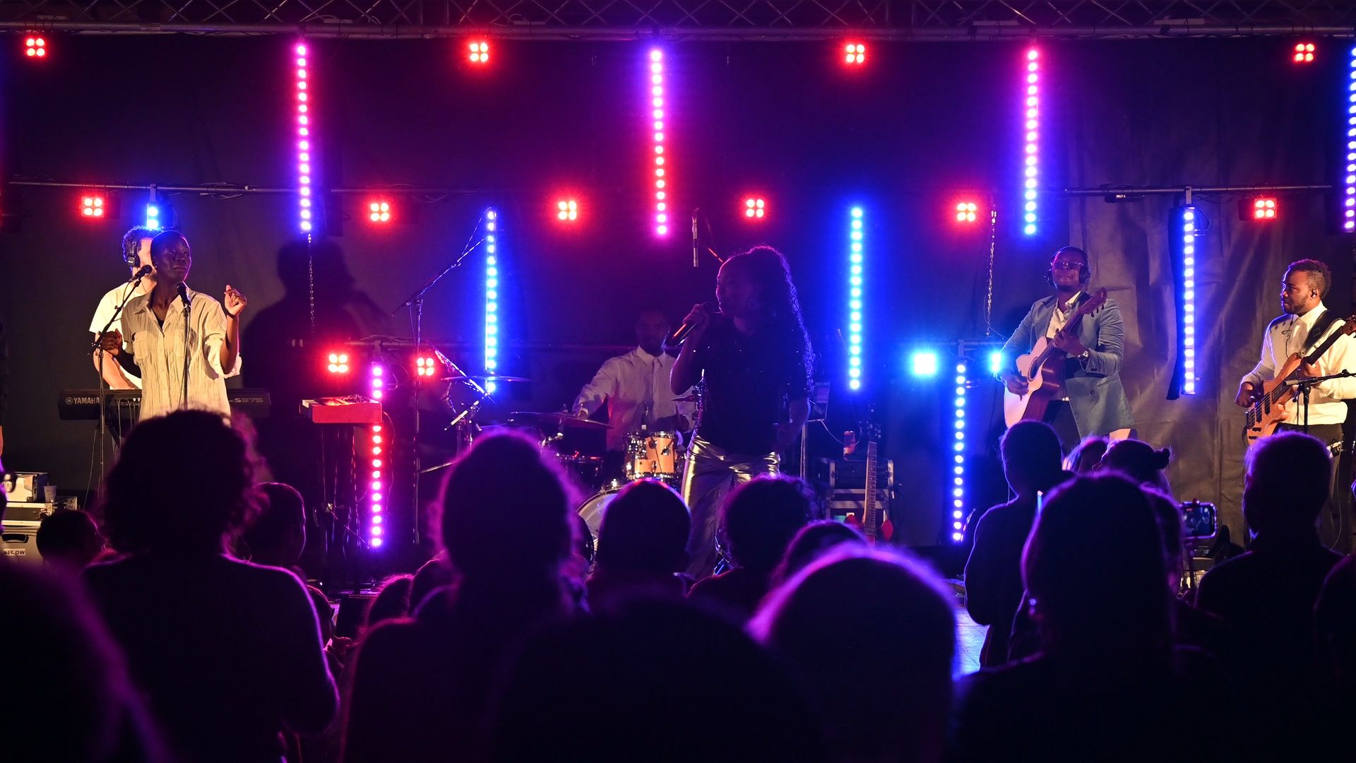 Un groupe se produisant devant une foule enthousiaste lors d'un concert nocturne.