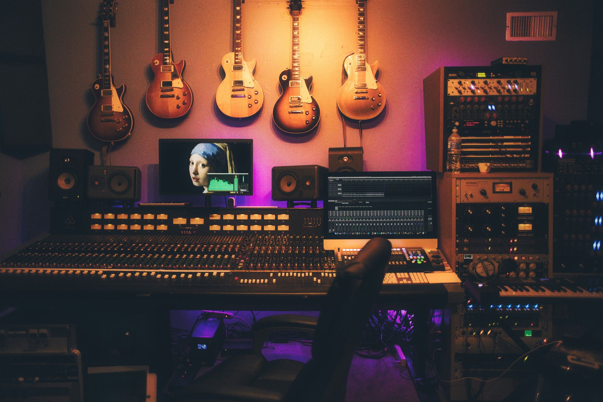 Un studio d'enregistrement avec des guitares accrochées au mur, créant une ambiance musicale inspirante.